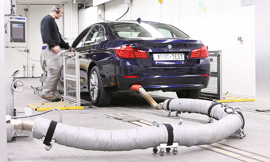 Ein Fahrzeug befindet sich in der Prüfung, am Auspuff hängt ein Schlauch.