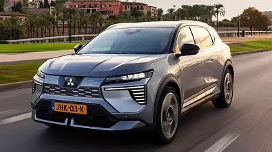 Der Mitsubishi Eclipse Cross (2026) fährt auf einer Straße, fotografiert von vorne schräg. - Foto: Mitsubishi