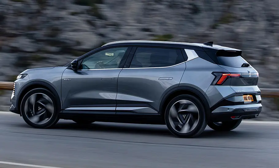Mitsubishi Eclipse Cross (2026) Der Mitsubishi Eclipse Cross (2026) fährt auf einer Straße, fotografiert von hinten schräg.