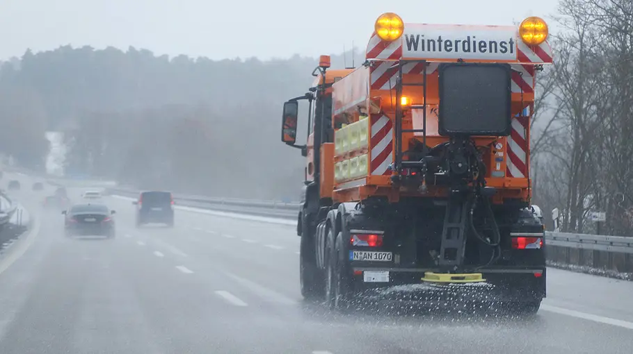 Streufahrzeug im Winterdienst Ein Streufahrzeug im Einsatz auf einer Autobahn.