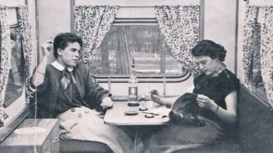 Zwei Frauen sitzen in der Sitzgruppe im Faltcaravan FaWoBoo (1962).