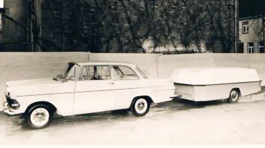 Der FaWoBoo (1962) hängt transportfertig an der Anhängerkupplung eines Zugfahrzeugs.