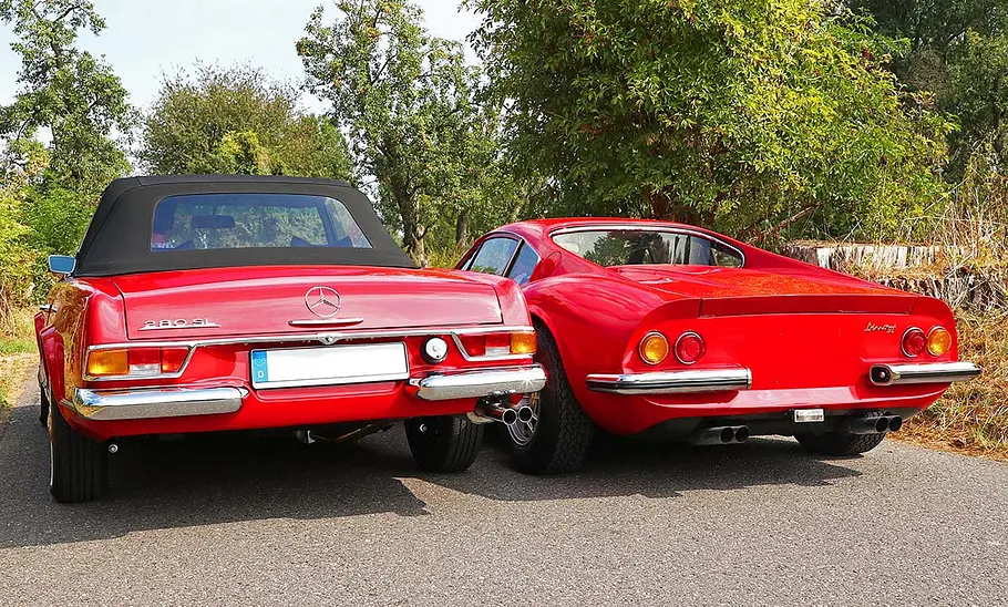Mercedes 280 SL (W113) und Ferrari Dino 246 GT stehend von hinten.