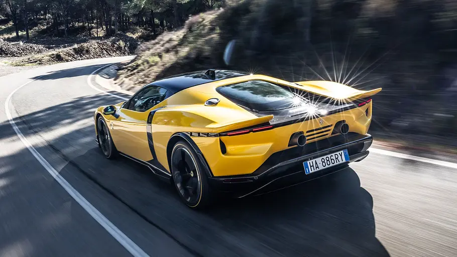 Der Ferrari 849 Testarossa fahrend von schräg hinten fotografiert.