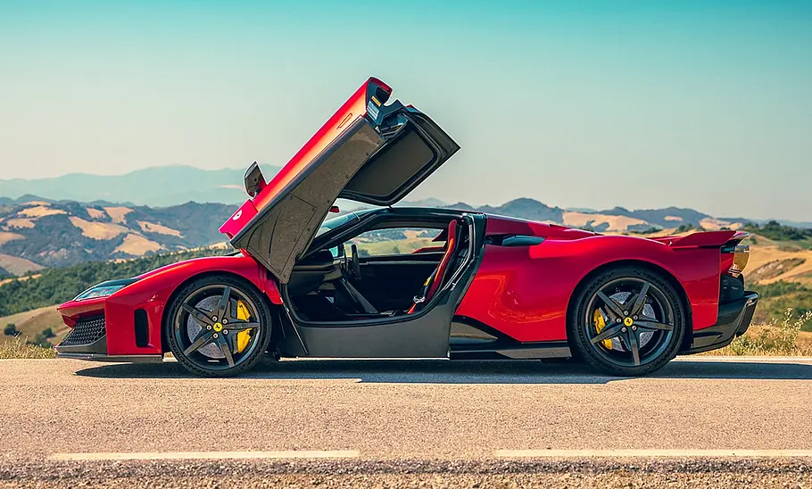 Der Ferrari F80 (2025) steht auf einer Landstraße zwischen Kornfeldern, fotografiert von der Seite.