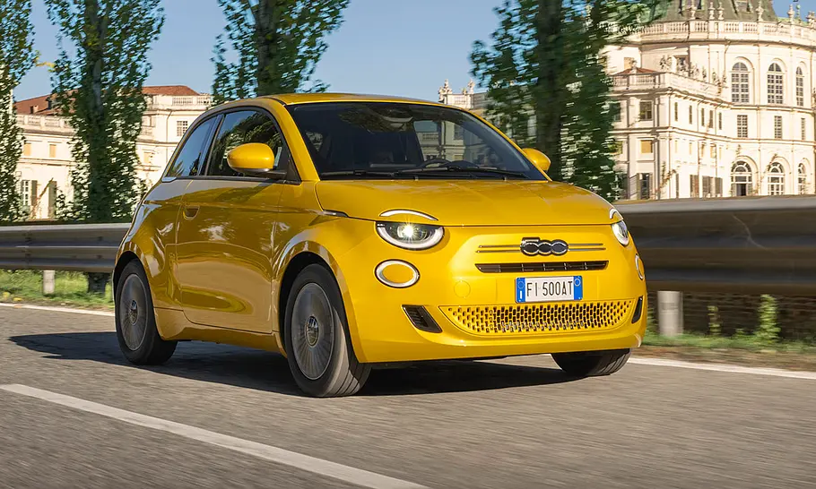 Fiat 500 Hybrid Torino Der Fiat 500 Hybrid Torino fährt auf einer Straße, fotografiert von vorne schräg.