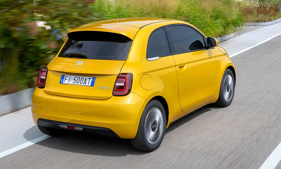 Fiat 500 Hybrid Torino Der Fiat 500 Hybrid Torino fährt auf einer Straße, fotografiert von hinten schräg.