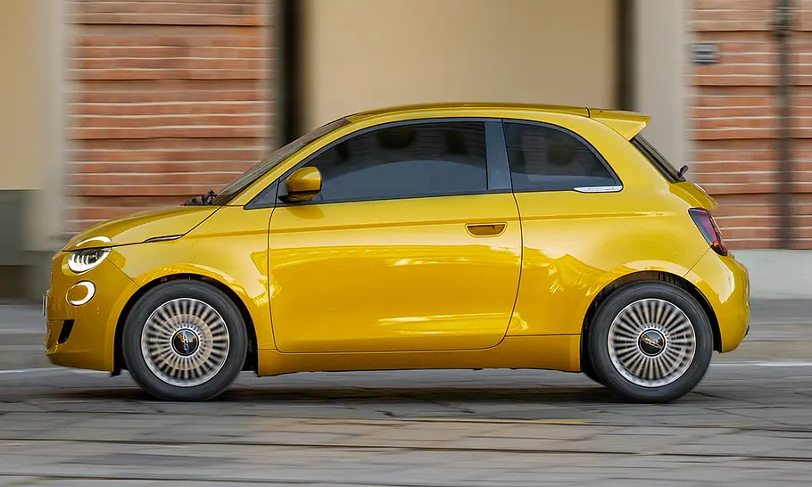 Fiat 500 Hybrid Torino Der Fiat 500 Hybrid Torino fährt durch eine Stadt, fotografiert von der Seite.