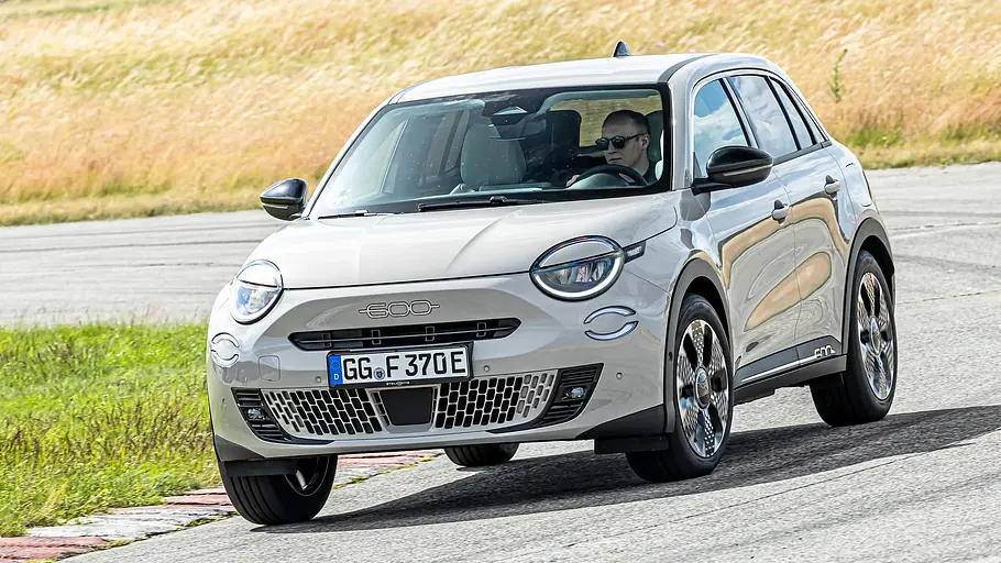 Weißer Fiat 600e fährt auf dem Testgelände durch eine Kurve