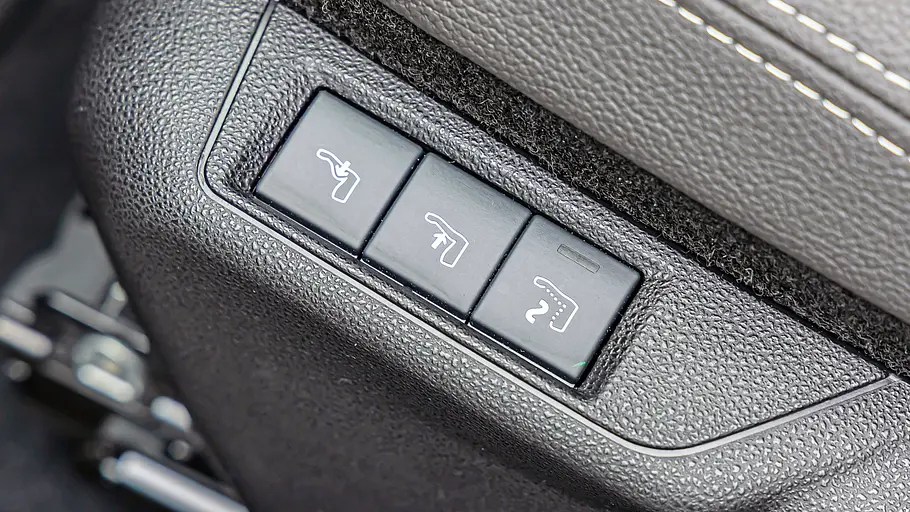 Nahaufnahme von drei Bedientasten an der Sitzwange des Fiat 600e