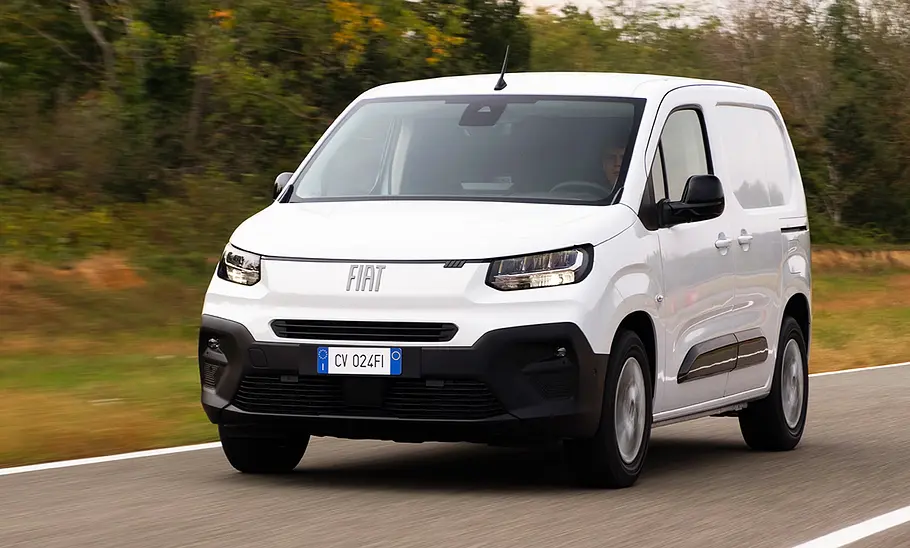 Fiat (E-)Doblò Facelift (2024) Das Fiat (E-)Doblò Facelift (2024) fährt auf einer Straße, von vorne links fotografiert.