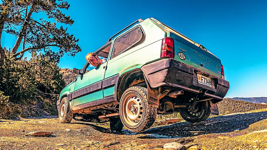 Blick von schräg hinten auf den Fiat Panda 4x4, der sich durch unwegsames Gelände kämpft.