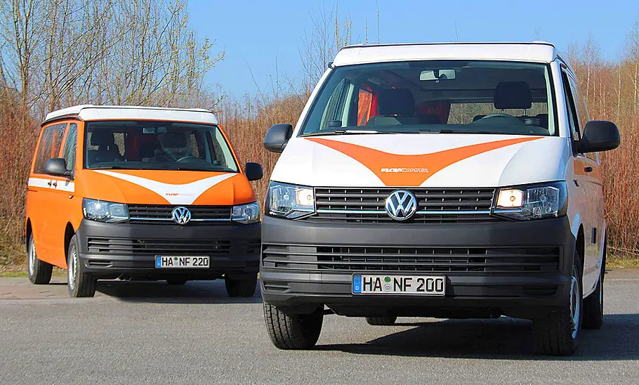 Flowcamper Frieda Das Bild zeigt zwei Modelle des Flowcamper Frieda stehend von schräg vorne fotografiert.