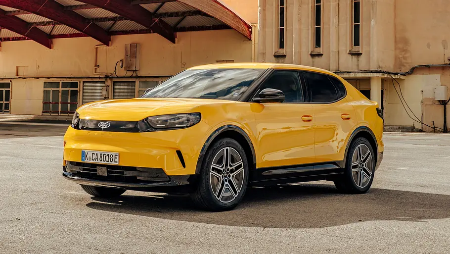 Ford Capri Leasing News Der Ford Capri statisch von schräg vorne links vor einer verlassenen Fabrikhalle.