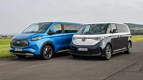Ford E-Tourneo Custon und VW Id. Buzz LWB fahren nebeneinander, von vorne links fotografiert. - Foto: Daniela Loof
