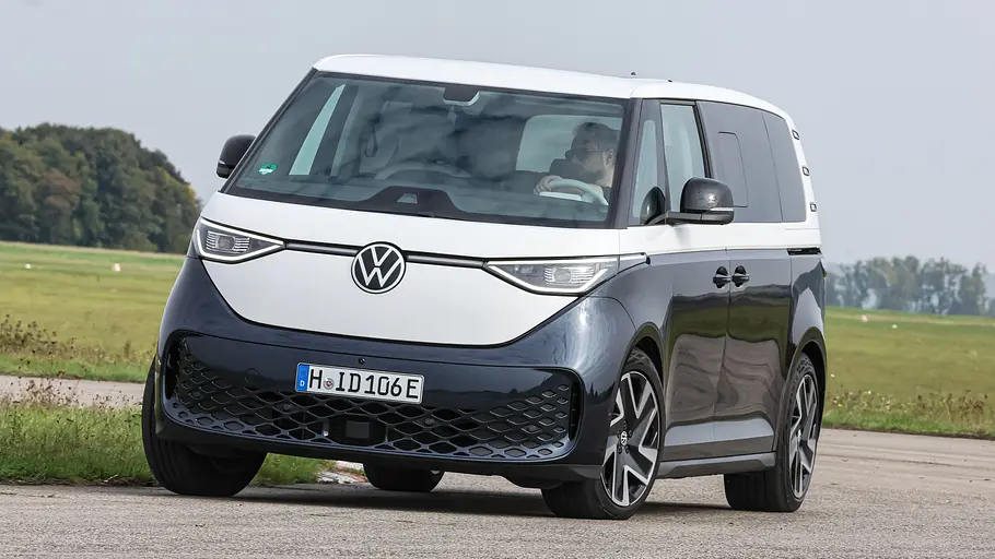 Der VW ID. Buzz LWB fährt durch eine Rechtskurve, von vorne links fotografiert.