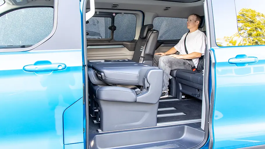 Ein Mann sitzt in der dritten Sitzreihe des Ford E-Tourneo Custom.