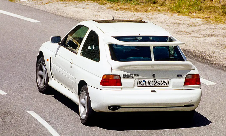 Der Ford Escort RS Cosworth fahrend von schräg hinten fotografiert.