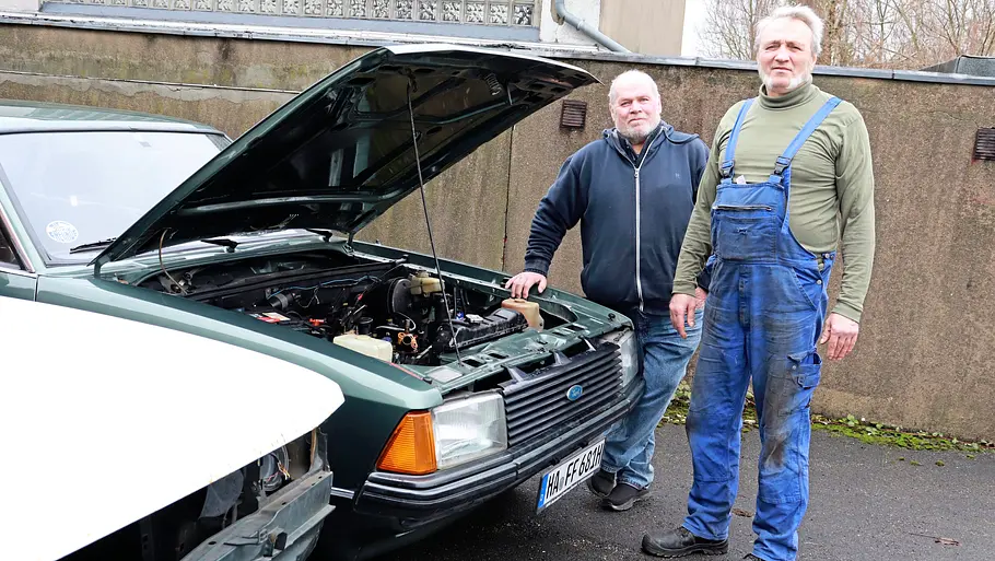 Zwei Personen stehend am Ford Granada II fotografiert. 
