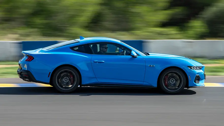 Der Ford Mustang GT fährt auf einer Rennstrecke, von rechts fotografiert.