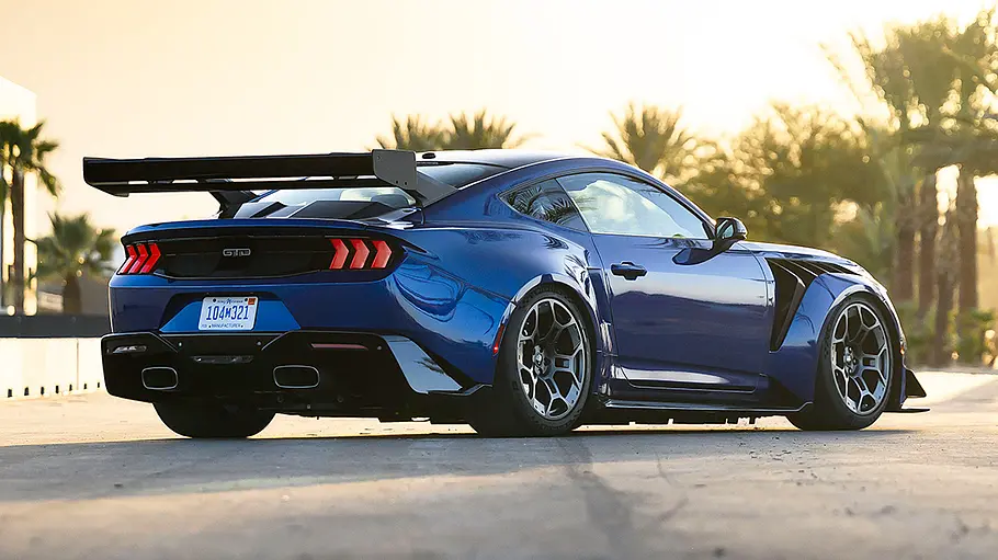 Der Ford Mustang GTD (2025) steht auf einer Straße, im Hintergrund Palmen. Von hinten rechts fotografiert.