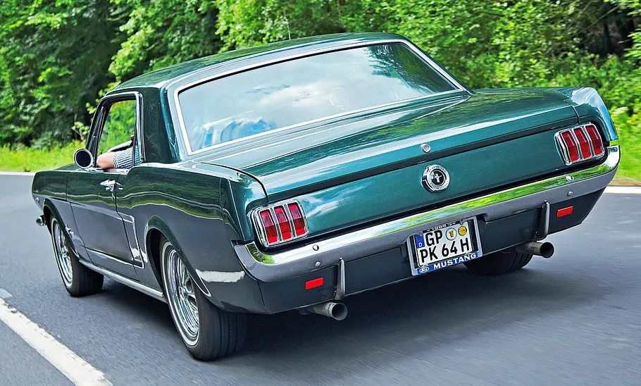 Der Ford Mustang fahrend von schräg hinten
