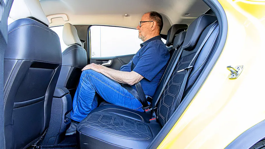 Ford Puma Gen-E Blick auf die Rückbank im Ford Puma Gen-e durch die linke geöffnete Hintertür. Aud dem rechten Platz sitzt eine Person.