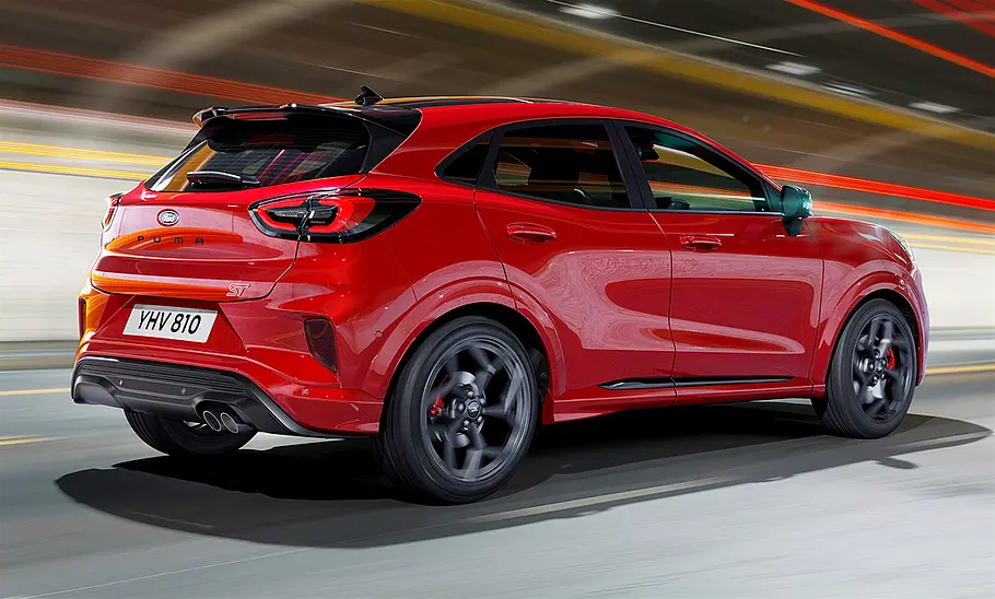 Das Ford Puma ST Facelift (2024) fahrend von schräg hinten.