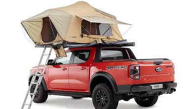 Ford Ranger mit Dachzelt von ARB aus dem Zubehörshop, stehend von schräg hinten fotografiert, das Dachzelt ist geöffnet, eine Leite auf Höhe der Fahrertür führt nach oben. - Foto: Ford/ARB