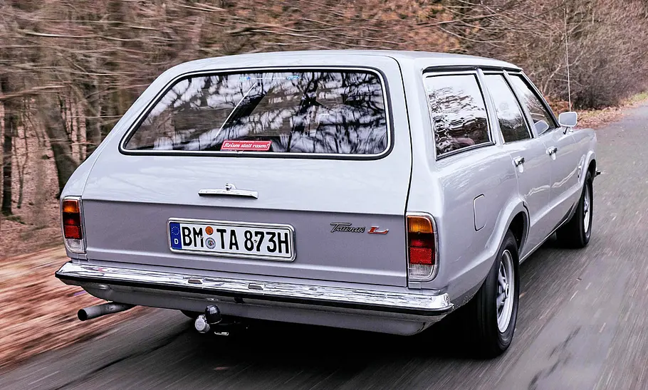 Der Ford Taunus TC Turnier fahrend von schräg hinten