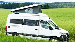 Das Bild zeigt den Yucon 6.0 BD (2019) mit geöffnetem Aufstelldach stehend von schräg vorne rechts fotografiert. - Foto: Yucon