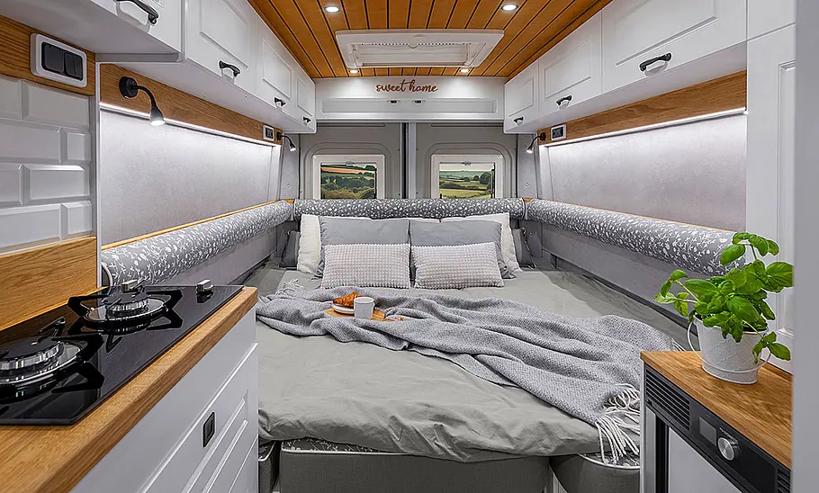 Freedo RV 599 LU (2025) Das Bild zeigt den Wohnraum des Freedo RV 599 LU (2025) in Doppelbett-Konfiguration vom Bug aus fotografiert.