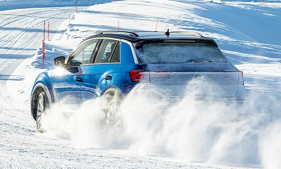 Ganzjahresreifen-Test Der VW T-Roc fahrend von schräg hinten fotografiert.