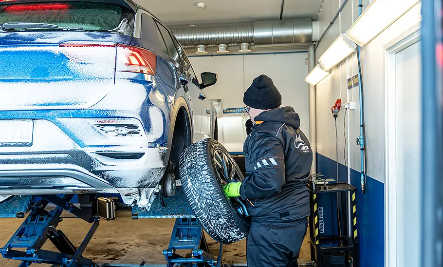 Ganzjahresreifen-Test Der VW T-Roc bekommt auf der Hebebühne ein Rad gewechselt.