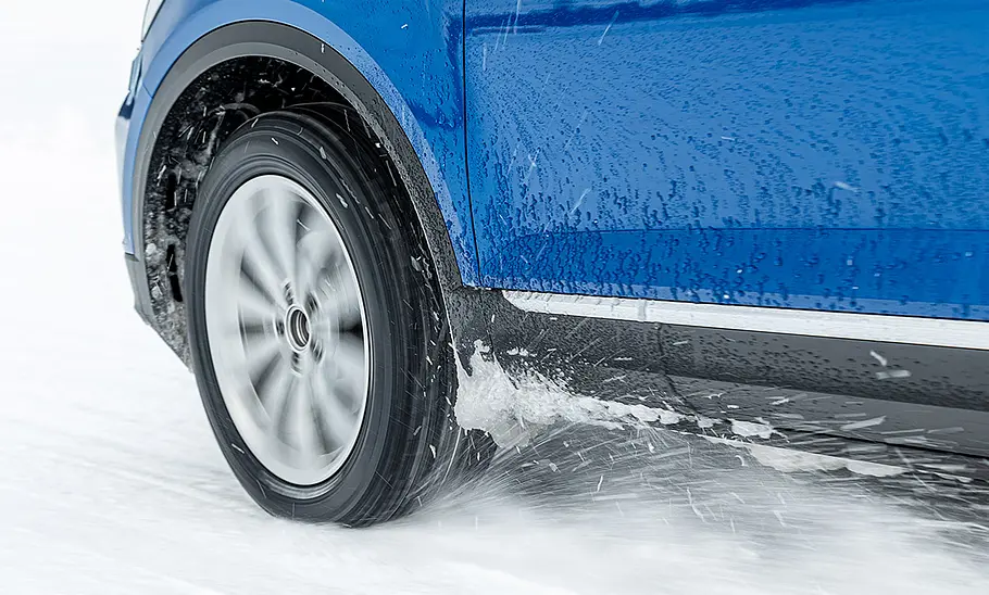 Ganzjahresreifen-Test Detailaufnahme eines rollenden Rades im Schnee.