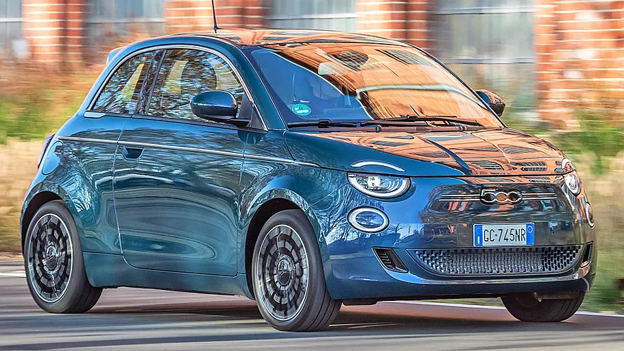 Der Fiat 500e fahrend von schräg vorne fotografiert.