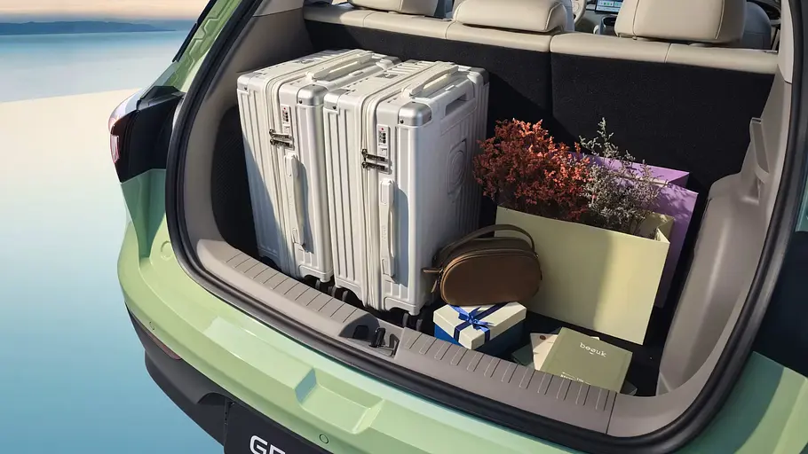 Der mit Koffern und Papiertüten beladene, geöffnete Kofferraum des Geely E2.
