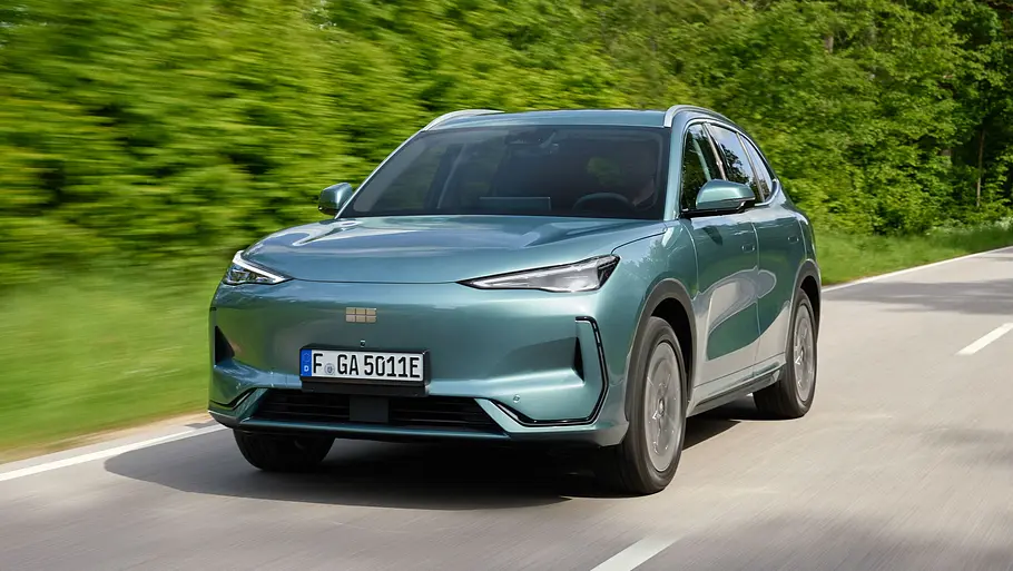 Der Geely E5 fährt auf einer Landstraße, von vorne links fotografiert.