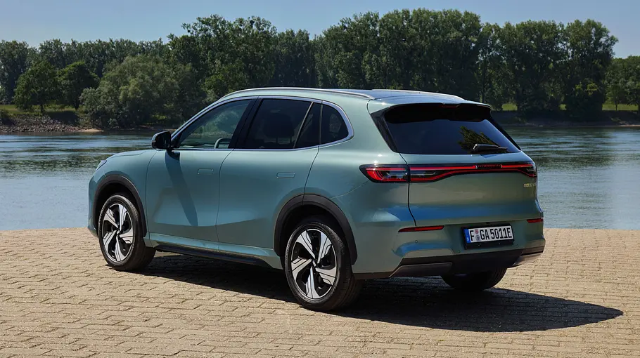 Der Geely E5 steht an einem Gewässer, von hinten links fotografiert.