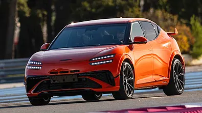 Blick von schräg vorne auf den fahrenden Genesis GV60 Magma (2026). - Foto: Genesis