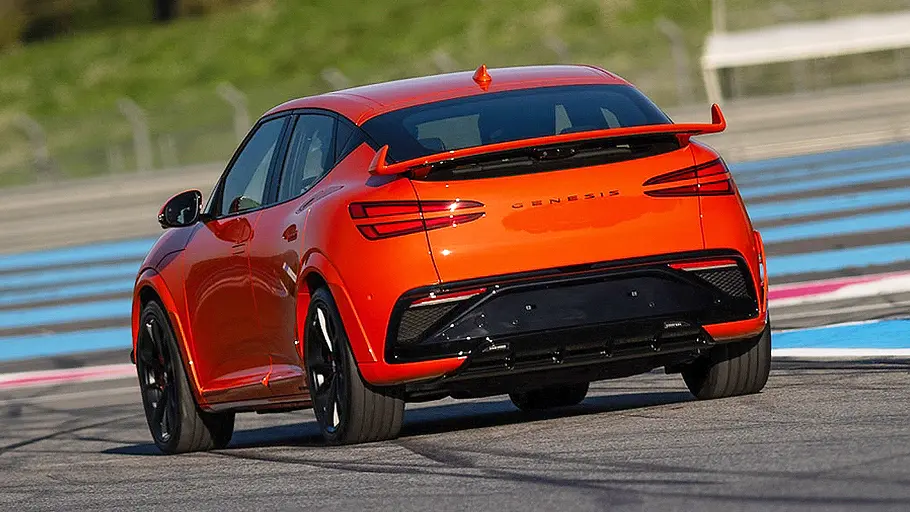 Blick von schräg hinten auf den fahrenden Genesis GV60 Magma (2026).