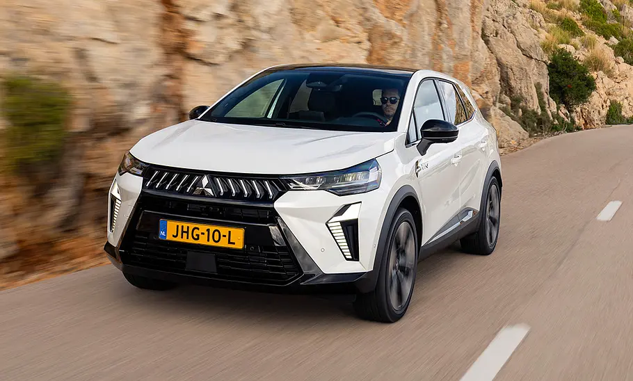 Der Mitsubishi Grandis (2025) fährt auf einer Passstraße, fotografiert von vorne schräg.