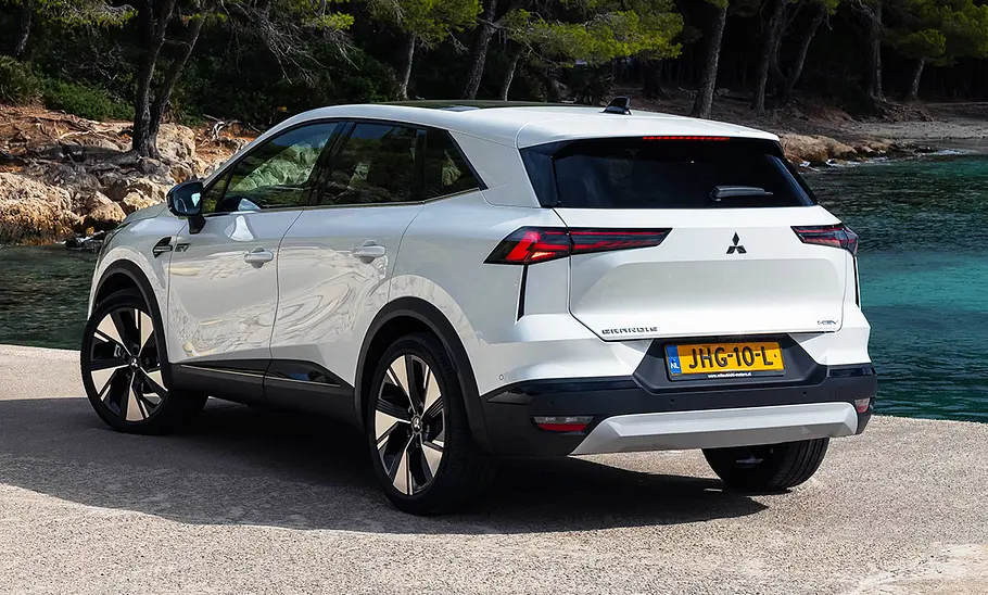 Der Mitsubishi Grandis (2025) steht auf einem Steinsteg und wurde von hinten schräg fotografiert.