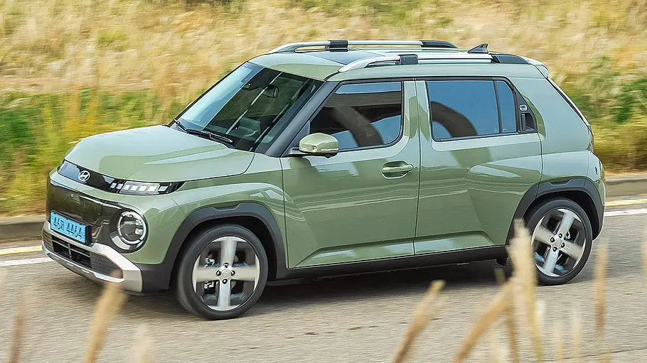 Hyundai Inster (2024) auf Landstraße fahrend, Ansicht von links.