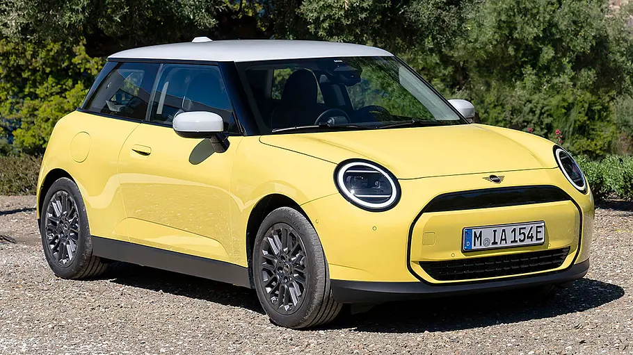Der Mini Cooper Electric steht auf Kies, von vorne rechts fotografiert.