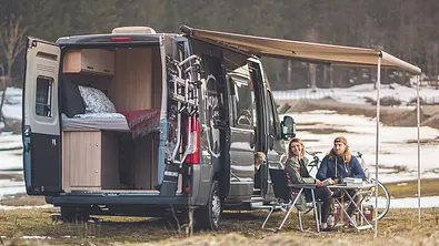 Die Außenaufnahme zeigt den stehenden Hannes Camper Van 60 (2024) mit geöffneten Hecktüren. - Foto: Hannes Camper