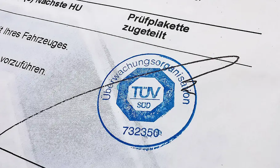 Ausschnitt einer Prüfbescheinigung der Kfz-Hauptuntersuchung mit Stempel des TÜV Süd