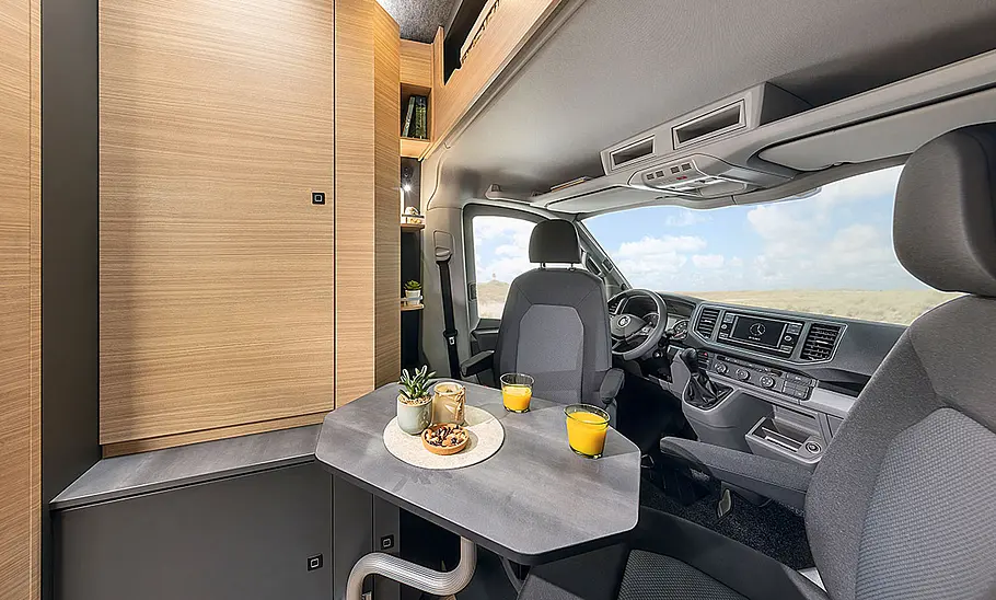 Das Bild zeigt die vordere Sitzgruppe des Hobby Maxia Van 680 DT (2024) mit Blick in Richtung Cockpit.