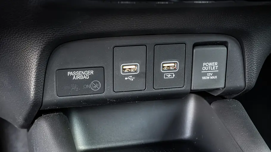 Die Leiste mit USB-Steckdosen und 12-V-Steckdose unter dem Armaturenbrett des Honda Jazz im Detail.