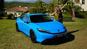 Blaues Sportcoupé Honda Prelude auf der Wiese einer Hotelanlage